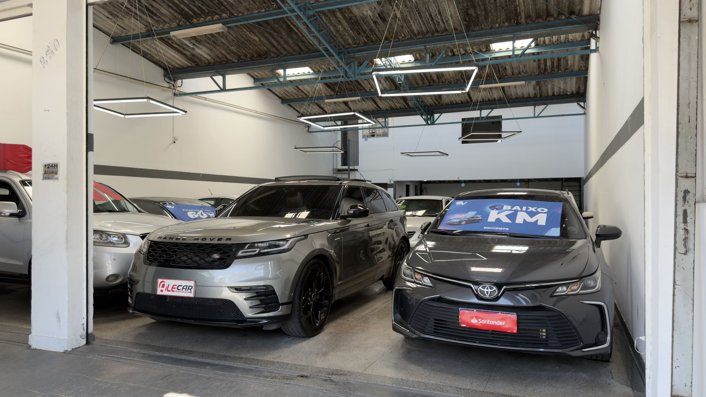 Salão da Alecar Multimarcas com uma Range Rover Velar e um Toyota Corolla